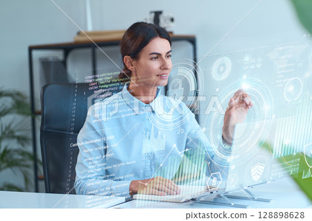 Businesswoman Interacting With Virtual Interface Displaying Data And Technology Concepts 128898628