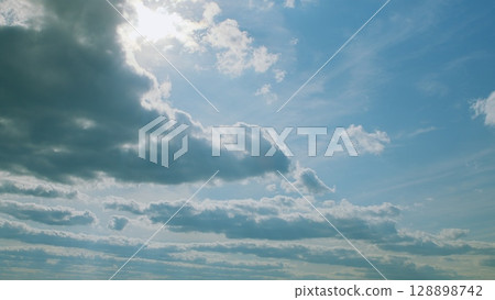 A Serene Cloudscape Embellished with Warm Golden Sunlight and a Gentle Sky Above 128898742
