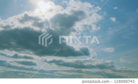 A Beautifully Serene and Cloudy Sky, Gracefully Accompanied by Soft and Warm Sunlight 128898743