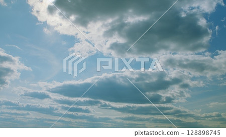 A Serene and Beautiful Cloudy Sky with Soft Sunlight Gently Peeking Through the Clouds 128898745