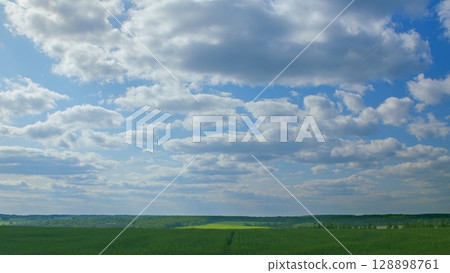 An Expansive Blue Sky Stretched Over Lush Green Fields of Natures Beauty and Serenity An Expansive Blue Sky Stretched Over Lush Green Fields of Natures Beauty and Serenity 128898761