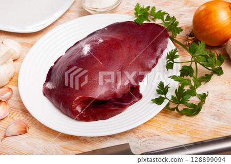 Raw pork liver ready for cooking on cutting board Raw pork liver ready for cooking on cutting board 128899094