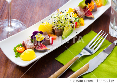 Tasty fried tuna with mango and avocado, served with fig and flower 128899146