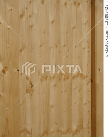 The wooden panel has a grainy texture and is brown in color The wooden panel has a grainy texture and is brown in color 128899425