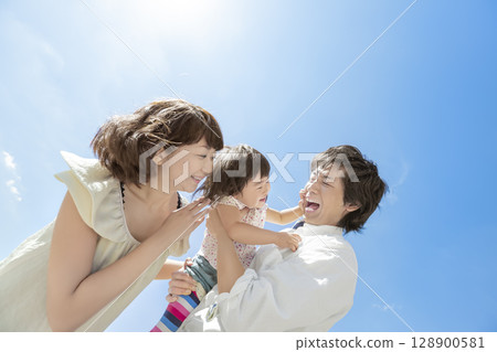 Three-person family playing in the park 128900581