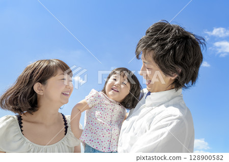 Three-person family playing in the park 128900582