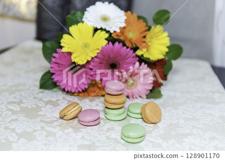 Colorful mix of macarons with a background of gerbers Colorful mix of macarons with a background of gerbers 128901170