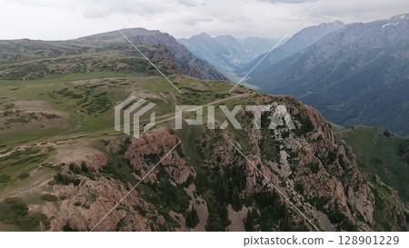 Off road vehicle conquering mountain pass, breathtaking aerial view of wilderness adventure Off road vehicle conquering mountain pass, breathtaking aerial view of wilderness adventure 128901229