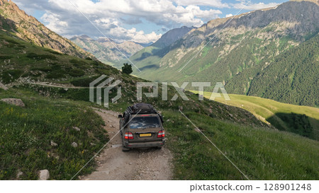 Off road vehicle conquering mountain path in kyrgyzstan's tien shan range 128901248