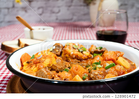 Delicious beef stew called carbonada with potatoes, corn, and carrots simmering in a rustic bowl 128901472