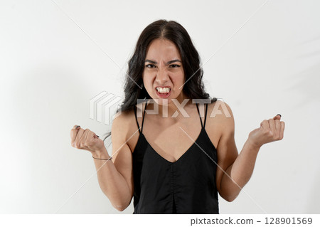 Angry young woman clenching fists showing teeth on white background 128901569