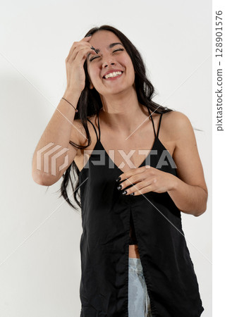 Young latin woman laughing and touching her forehead while posing on white background 128901576