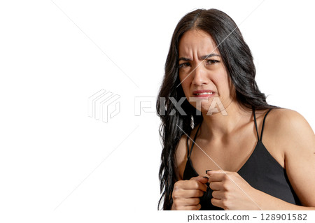 Young latin woman showing disgust and grimacing on white background 128901582