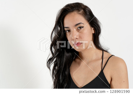 Young latin woman posing with serious expression on white background 128901590
