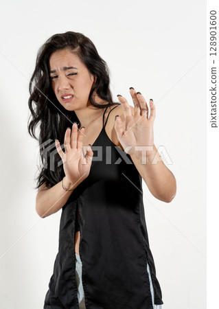 Young woman showing disgust and rejection with hand gestures Young woman showing disgust and rejection with hand gestures 128901600