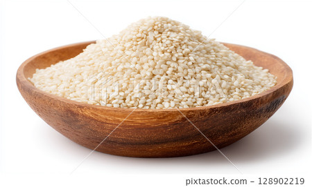 Beautiful food photography of white sesame seeds piled high in a wooden bowl 128902219