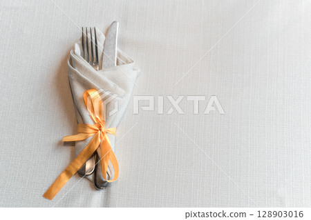 Elegant Cutlery Wrapped in Napkin with Ribbon 128903016