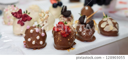 Gourmet Chocolate Strawberries with Toppings on Display 128903055