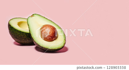 Ripe avocado halves on pastel pink background with bold shadow. Concept of superfood aesthetics, healthy fats, clean eating visuals, healthy food, and plant-based nutrition for wellness branding 128903338