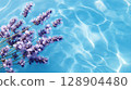 Lavender flowers on blue water surface, creating serene scene 128904480