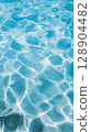 Clear blue water surface with gentle ripples and reflections 128904482