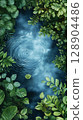 Lush greenery surrounding tranquil water surface 128904486