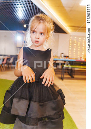 Little beautiful girl in black dress at disco 128905353