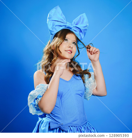 Cute teenage girl in blue doll dress with big blue bow posing. 128905393