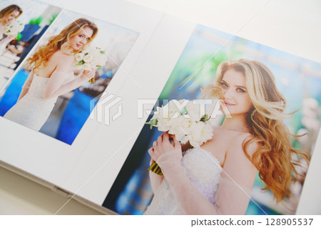 the pages of a photo book with wedding photos.  128905537