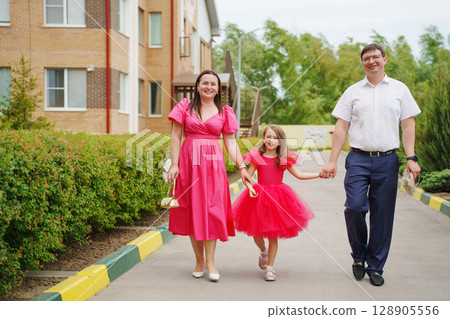 Happy well-dressed family on a walk. Happy well-dressed family on a walk. 128905556