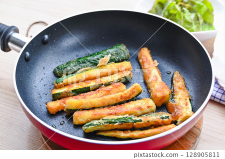 Fried zucchini in a frying pan 128905811