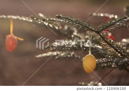 A tree with two eggs hanging from it 128906180