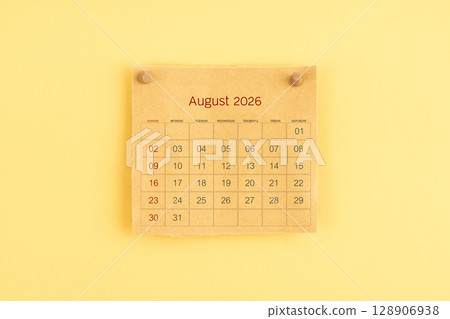 August 2026 brown calendar with wooden thumbtack on yellow color background. 128906938