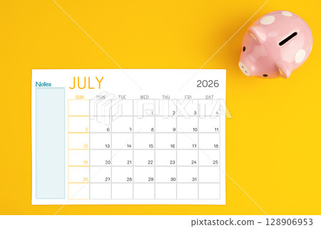 July 2026 calendar and pink piggy bank. Money savings challenge concepts. July 2026 calendar and pink piggy bank. Money savings challenge concepts. 128906953