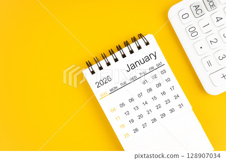 January 2026 calendar and calculator on yellow background, Flat lay. 128907034