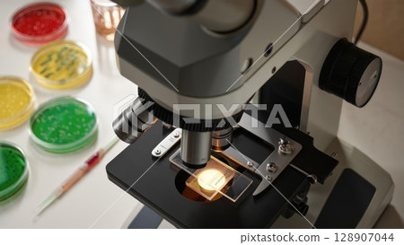 Close-up of microscope and Petri dishes in a bright lab. Represents science, discovery, and modern research tools. Generative AI. 128907044