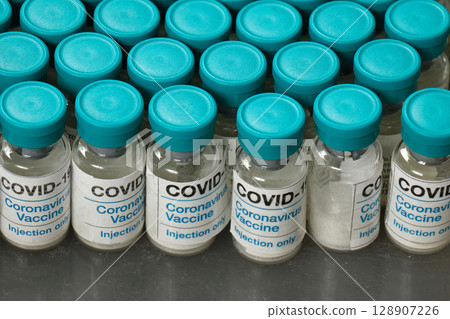 Covid-19 vaccines on factory conveyor 128907226