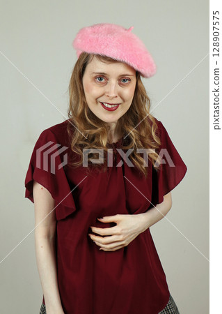 Woman smiling with hand on stomach Woman smiling with hand on stomach 128907575