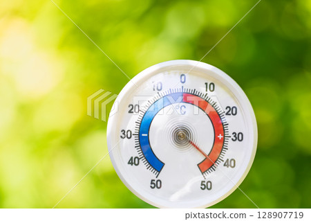 Thermometer in natural setting showing heatwave conditions in summer 128907719