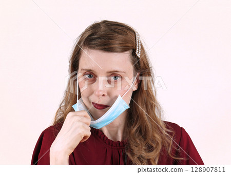 Taking off face mask 128907811