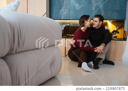 Cozy couple sharing a quiet moment in a modern living room setting Cozy couple sharing a quiet moment in a modern living room setting 128907875