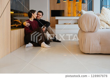 Cozy moment between a couple in a modern living room during the evening 128907878