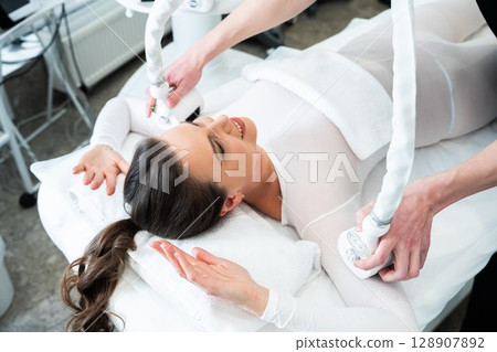 Woman receiving a body sculpting treatment at a wellness center Woman receiving a body sculpting treatment at a wellness center 128907892
