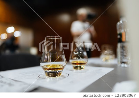 Enjoying fine whiskey at a tasting event in a cozy, intimate venue Enjoying fine whiskey at a tasting event in a cozy, intimate venue 128908067