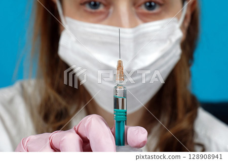 Syringe and needle in front of face 128908941