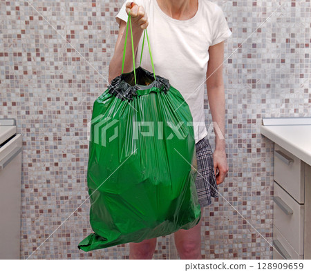 Holding trash bag at home 128909659