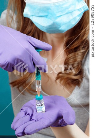 Nurse with face mask holding vaccine 128909755