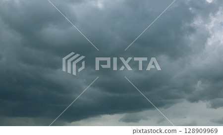Dramatic and Chaotic Dark Clouds Loom Overhead, Creating a Gloomy and Turbulent Atmosphere Dramatic and Chaotic Dark Clouds Loom Overhead, Creating a Gloomy and Turbulent Atmosphere 128909969