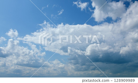 A Beautiful and Cloudy Sky Overcast with a Stunningly Bright Blue Background behind it 128909989
