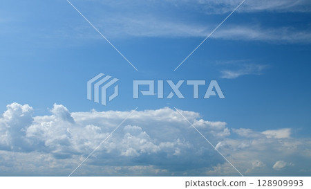 A Serene Blue Sky with Fluffy Clouds, capturing the essence of a tranquil and beautiful day 128909993